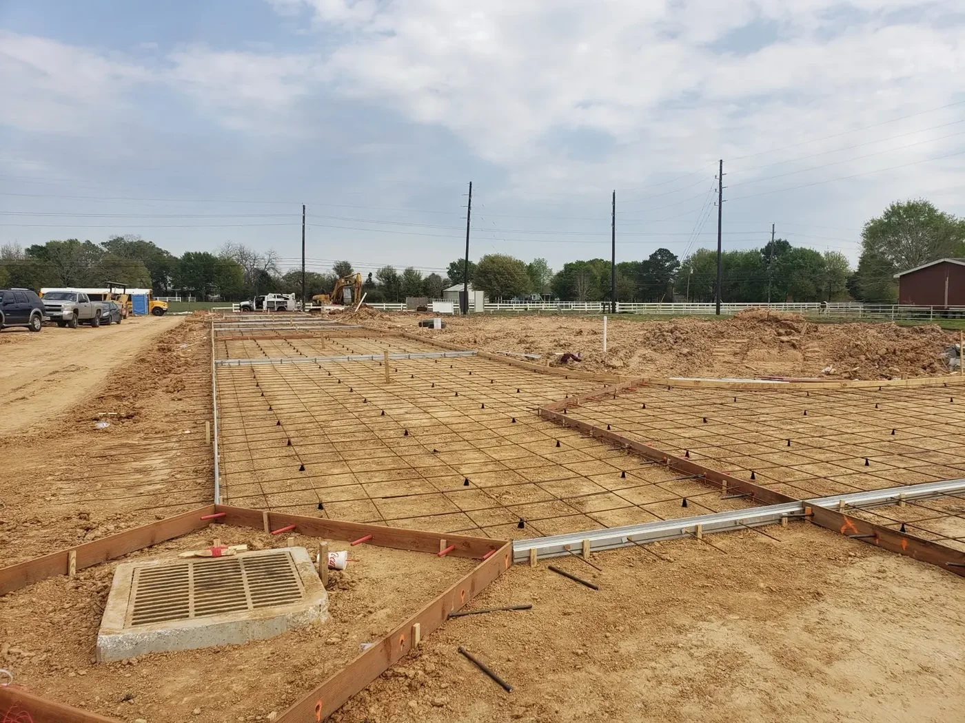Large commercial building pad with a rebar grid laid out and edge forms set ahead of a concrete pour